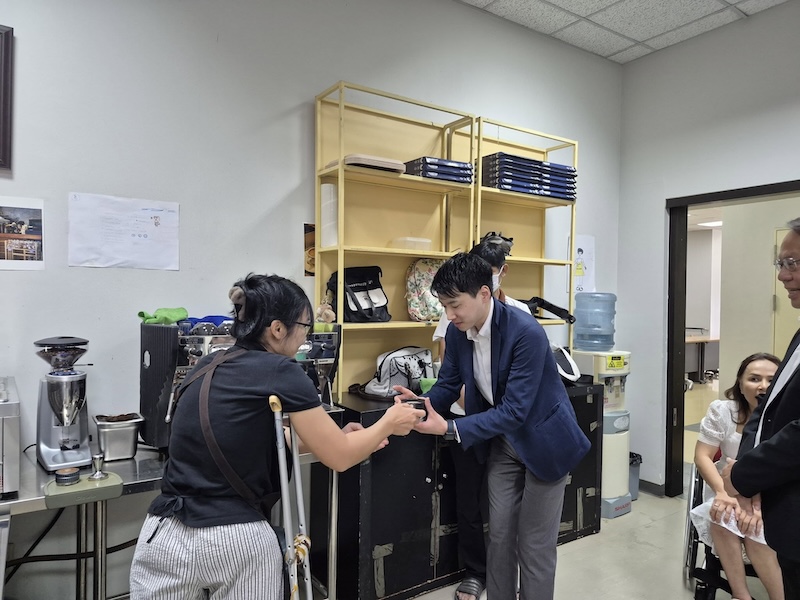 Mr. KAMIESU Yuki try hot chocolate made from disability-barista trainer